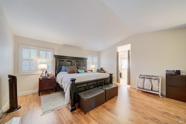 bedroom featuring lofted ceiling, light wood-style floors, and baseboards