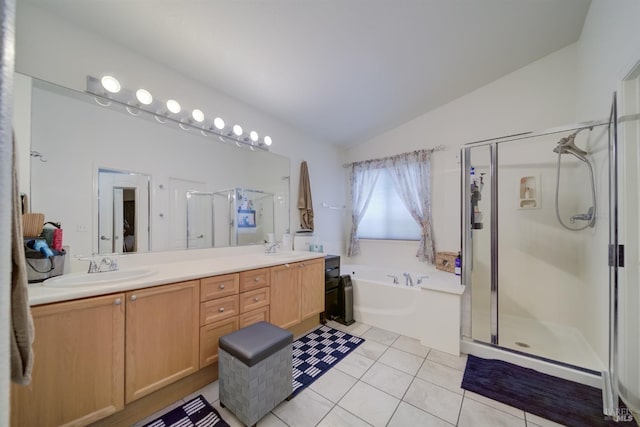 bathroom featuring a stall shower, tile patterned flooring, vaulted ceiling, and double vanity