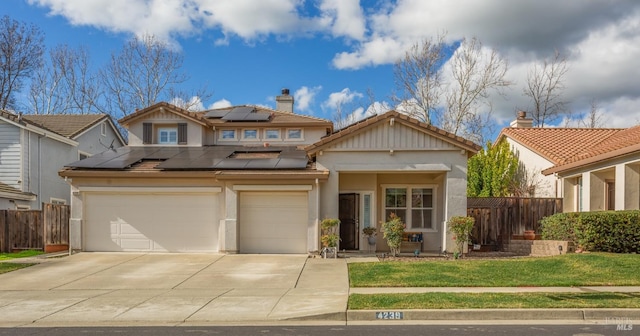 view of front of property with driveway, a garage, fence, roof mounted solar panels, and a front lawn