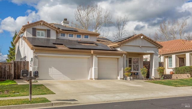 view of front facade with a chimney, solar panels, stucco siding, concrete driveway, and fence
