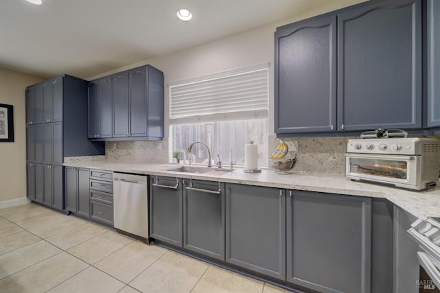 kitchen with a toaster, backsplash, light countertops, stainless steel dishwasher, and a sink
