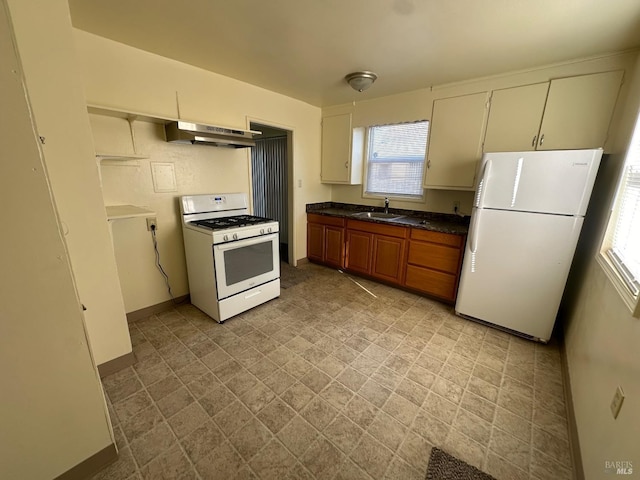 kitchen with sink, a wealth of natural light, and white appliances