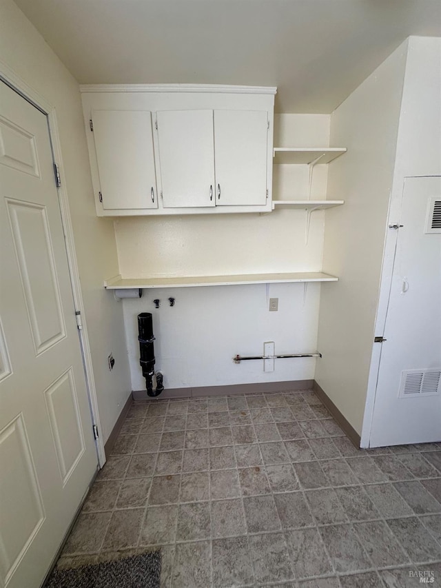 laundry area with gas dryer hookup and cabinets