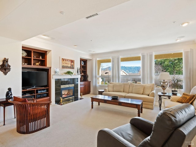 carpeted living room featuring crown molding, plenty of natural light, a fireplace, and built in features