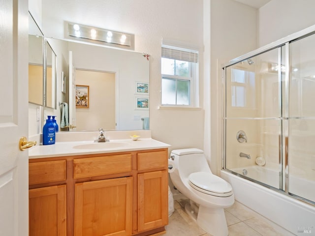 full bathroom featuring enclosed tub / shower combo, vanity, tile patterned floors, and toilet