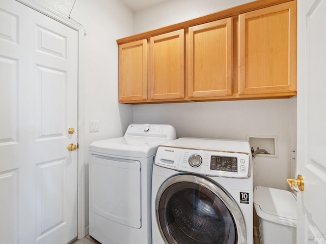 washroom with cabinets and washing machine and dryer