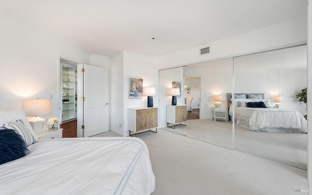 carpeted bedroom featuring ornamental molding and a closet