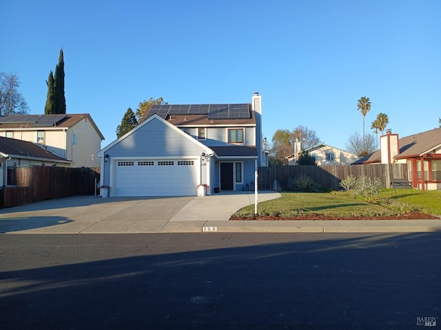 view of front facade with a garage, a front lawn, and solar panels