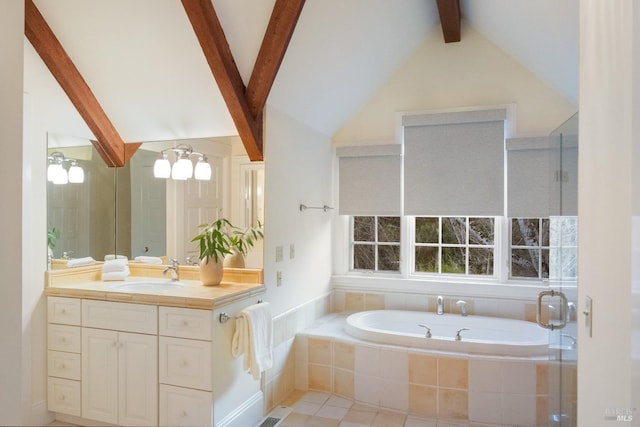 bathroom featuring lofted ceiling with beams, vanity, and tiled tub