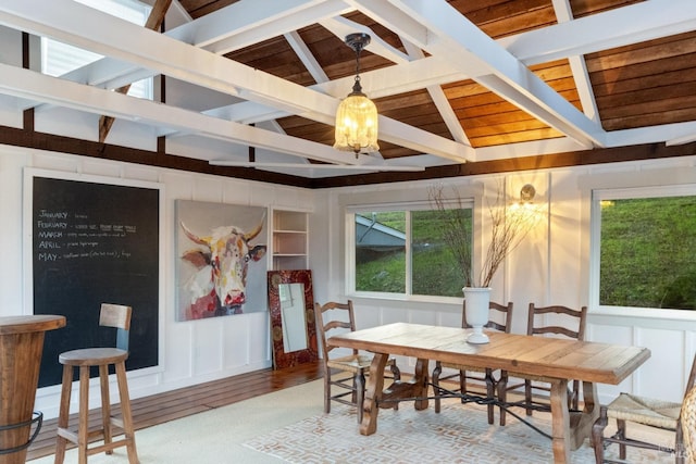 dining space featuring hardwood / wood-style flooring, vaulted ceiling with beams, and a notable chandelier