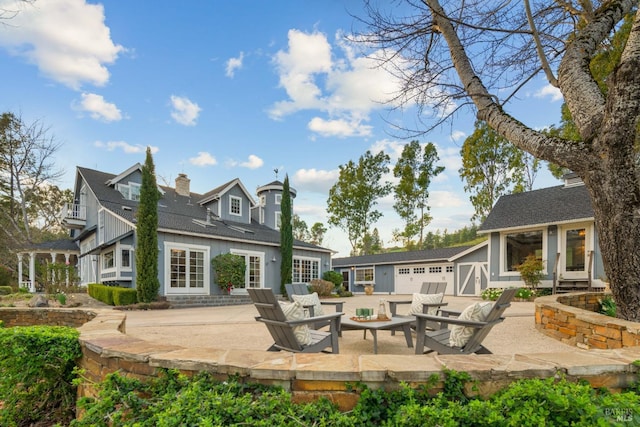 back of house with a garage and a patio area