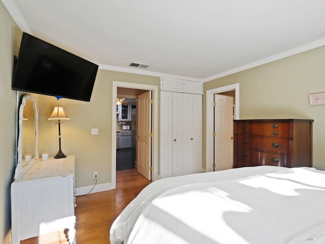 bedroom featuring ornamental molding, light hardwood / wood-style floors, and a closet