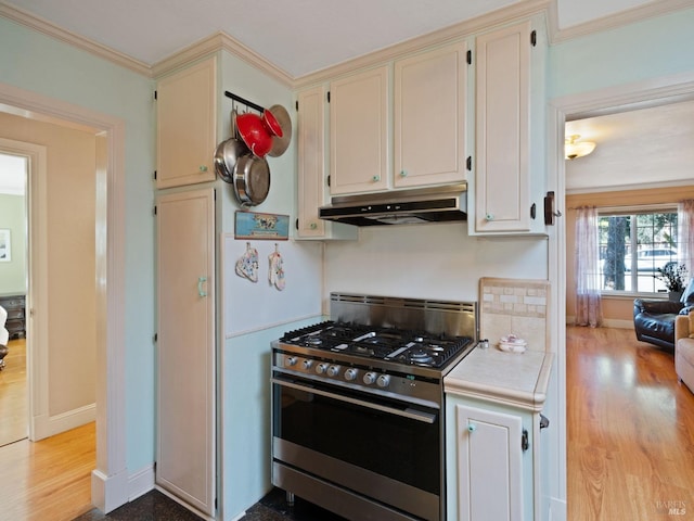 kitchen featuring stainless steel gas range, ornamental molding, and light wood-type flooring