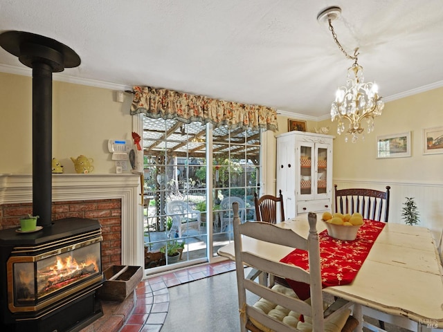 dining space featuring crown molding, a wood stove, and a notable chandelier