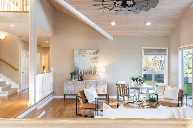 living area featuring high vaulted ceiling, baseboards, stairway, and wood finished floors