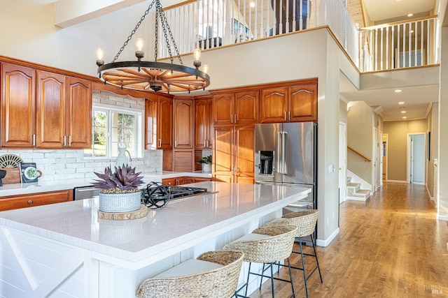 kitchen with stainless steel appliances, a center island, light countertops, and light wood finished floors