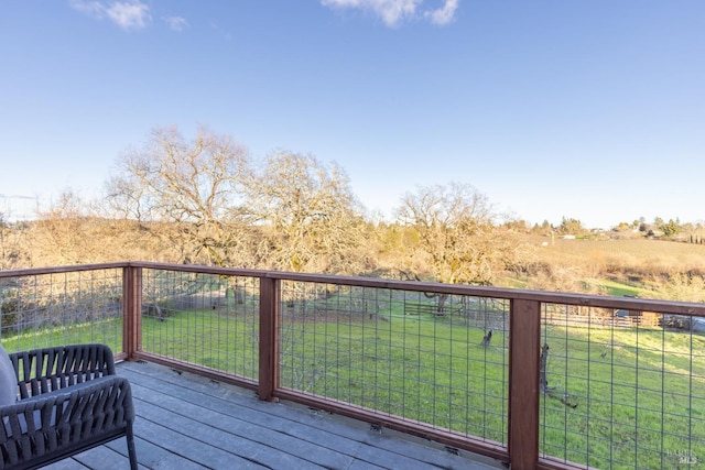 wooden deck featuring a rural view and a yard