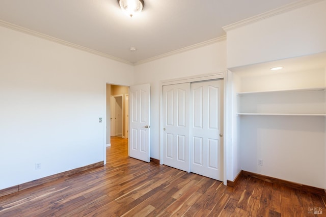 unfurnished bedroom featuring a closet, baseboards, crown molding, and wood finished floors