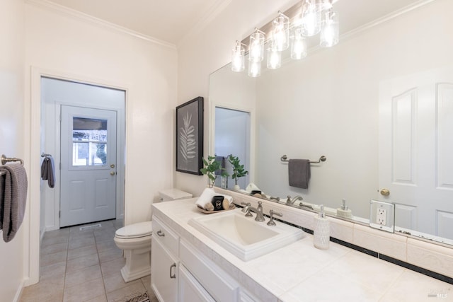 bathroom with toilet, vanity, crown molding, and tile patterned floors