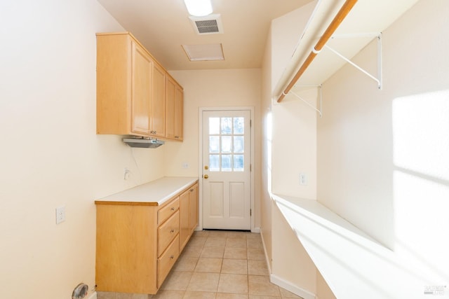 laundry area featuring light tile patterned floors and visible vents