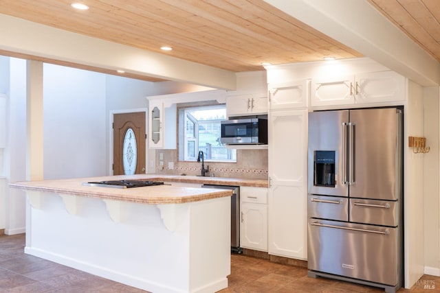 kitchen with wooden ceiling, white cabinetry, light countertops, appliances with stainless steel finishes, and tasteful backsplash