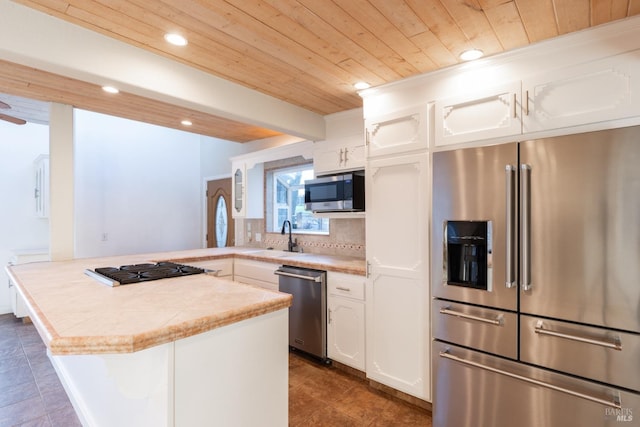 kitchen with wooden ceiling, stainless steel appliances, a peninsula, a sink, and light countertops