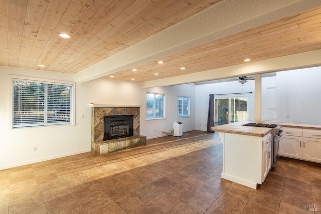 kitchen featuring white cabinets, high end stainless steel range oven, wooden ceiling, and open floor plan