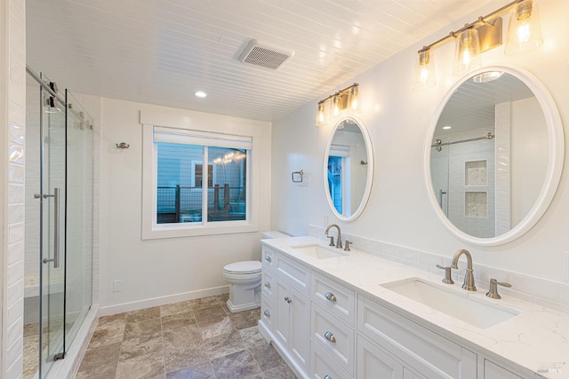 bathroom featuring a stall shower, baseboards, visible vents, and a sink