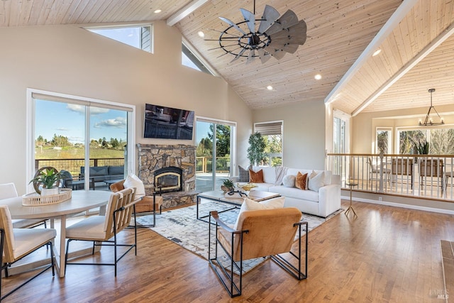 living room with wooden ceiling, wood finished floors, a fireplace, high vaulted ceiling, and ceiling fan with notable chandelier