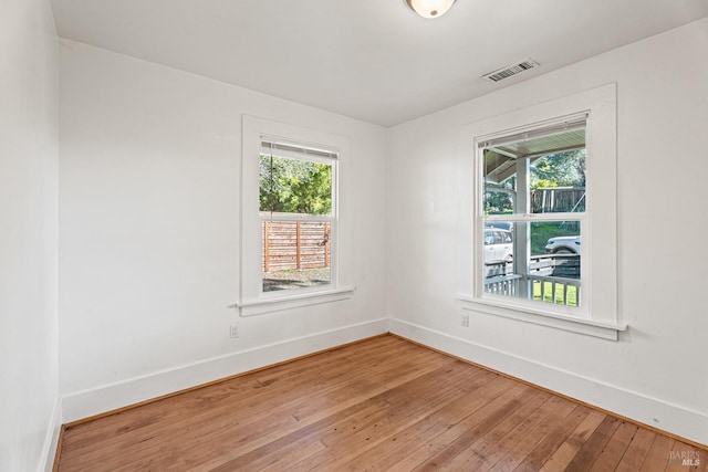 unfurnished room featuring wood-type flooring and a wealth of natural light