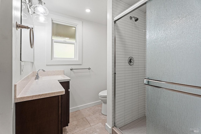 bathroom featuring a shower with door, vanity, tile patterned floors, and toilet