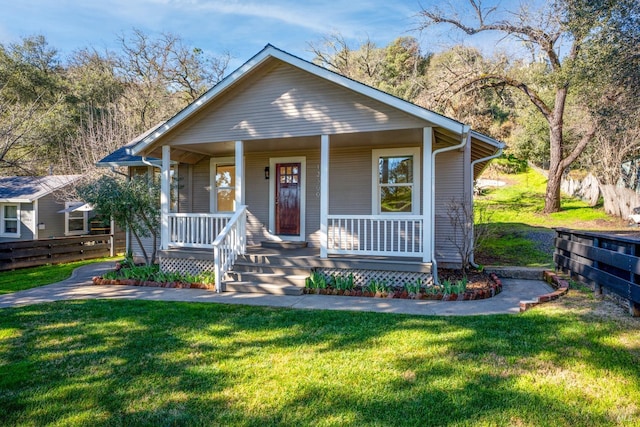 bungalow-style home with a front yard and covered porch