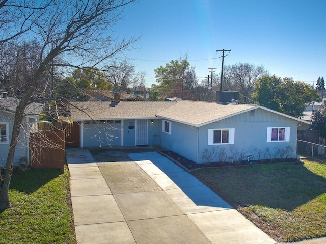 ranch-style house with an attached garage, fence, concrete driveway, roof with shingles, and a front lawn