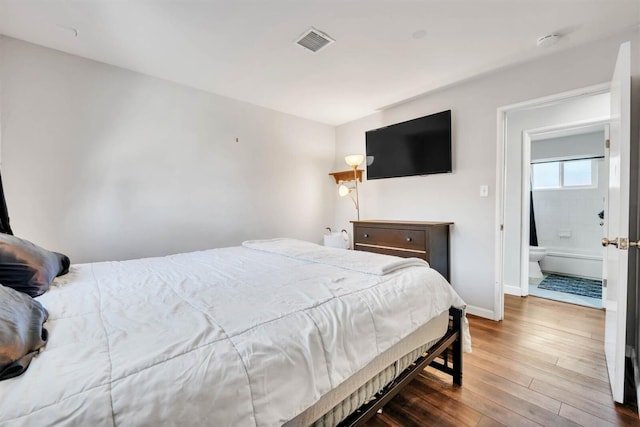 bedroom featuring wood-type flooring, baseboards, and visible vents