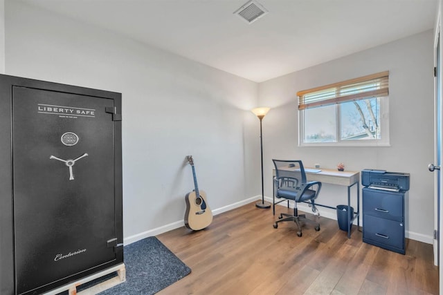 office featuring baseboards, wood finished floors, and visible vents