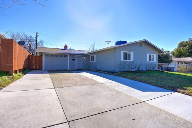 ranch-style house with a garage, concrete driveway, fence, a front lawn, and stucco siding