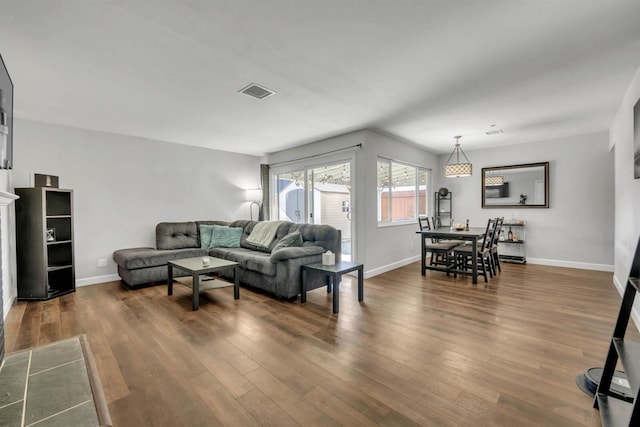 living area featuring baseboards, dark wood-type flooring, and visible vents