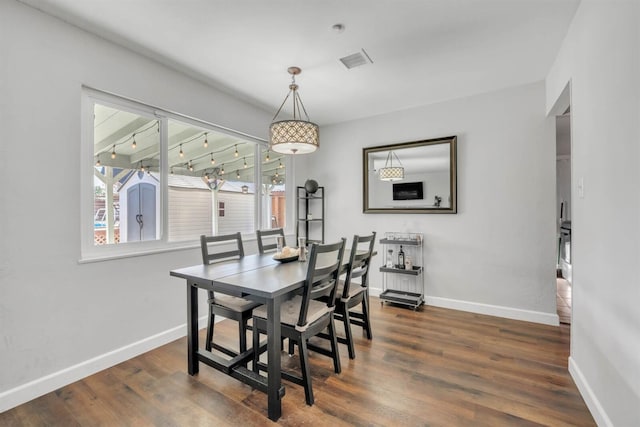 dining area featuring visible vents, wood finished floors, and baseboards