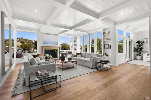 living room featuring coffered ceiling, plenty of natural light, light hardwood / wood-style floors, and beamed ceiling