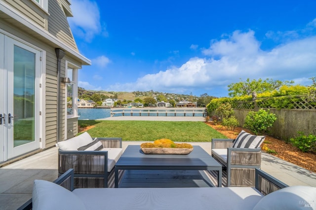 view of patio featuring a swimming pool, an outdoor hangout area, a water view, and fence