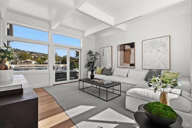 living room featuring beamed ceiling and light wood-type flooring