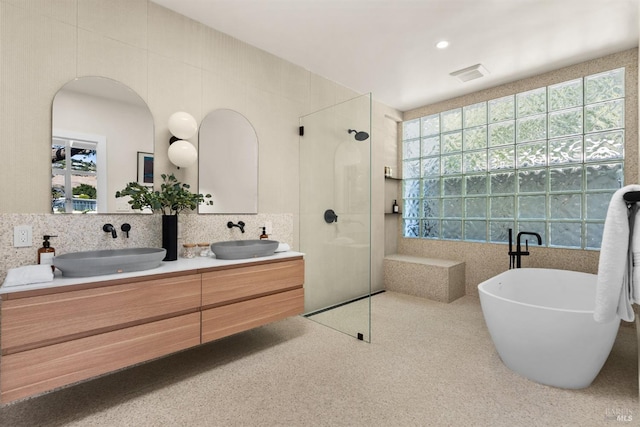 bathroom with vanity, independent shower and bath, and tile walls