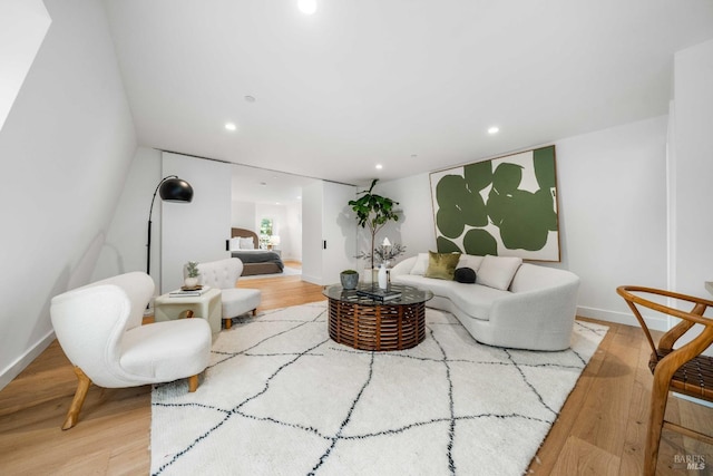living area featuring baseboards, light wood-style flooring, and recessed lighting