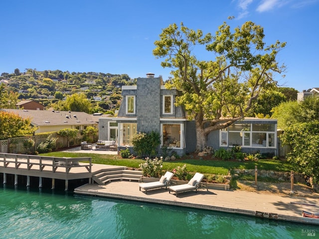 back of house featuring a chimney, a fenced backyard, a sunroom, an outdoor pool, and a patio