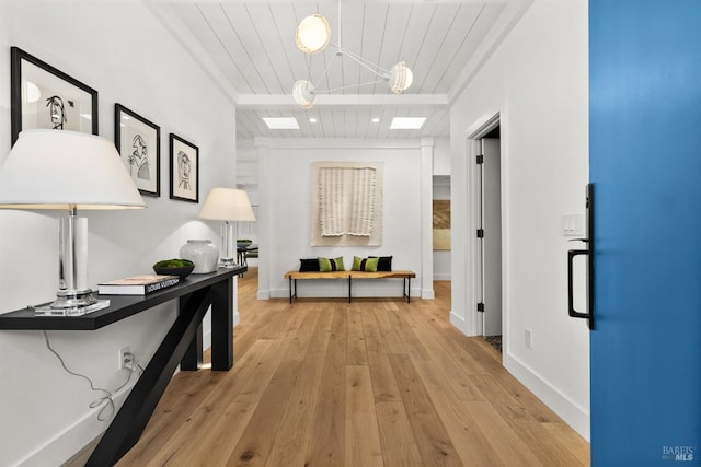 corridor featuring light hardwood / wood-style flooring and wooden ceiling