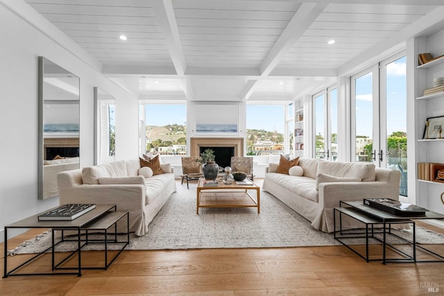 living area with beamed ceiling, a fireplace, recessed lighting, and hardwood / wood-style floors
