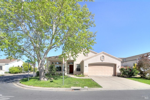 mediterranean / spanish home featuring an attached garage, a front lawn, stucco siding, and concrete driveway