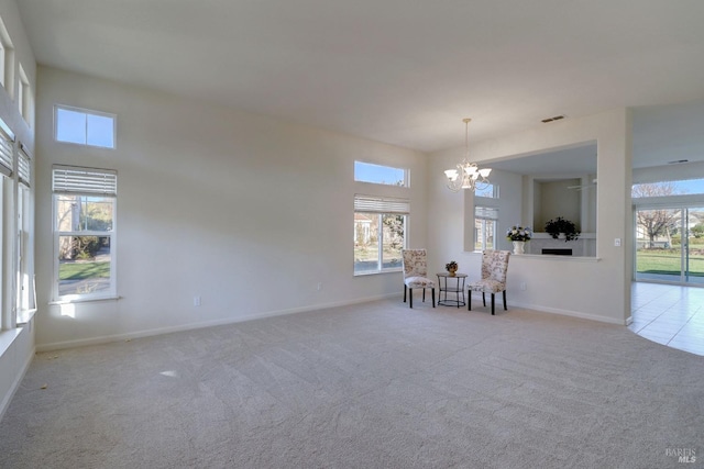 unfurnished room featuring a high ceiling, light colored carpet, and a chandelier