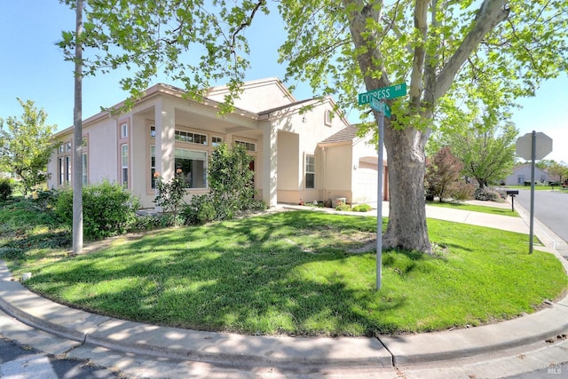 view of front of house featuring a front lawn and stucco siding