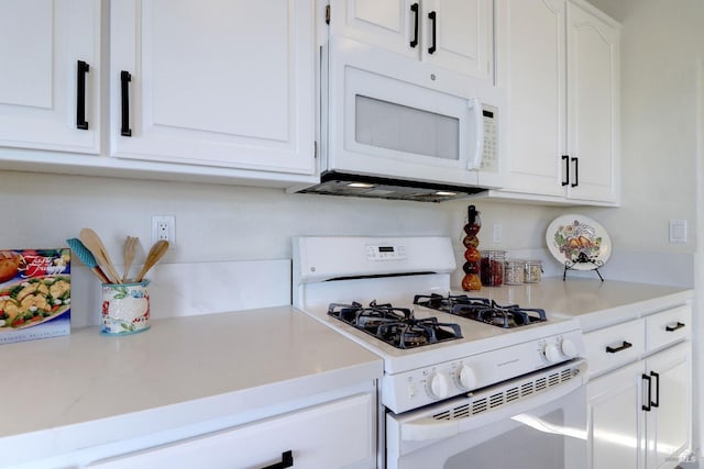 kitchen with light countertops, white appliances, and white cabinetry